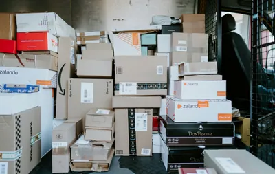 A stack of cardboard shipping boxes inside the back of a delivery van