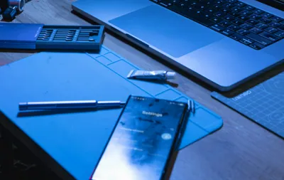 Laptop and phone on a desk with coding software open