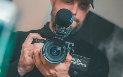 Man wearing a baseball cap holding a camera